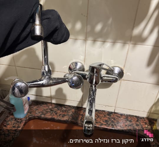 ברז מטבח מותקן מעל כיור עם אריחי קרמיקה